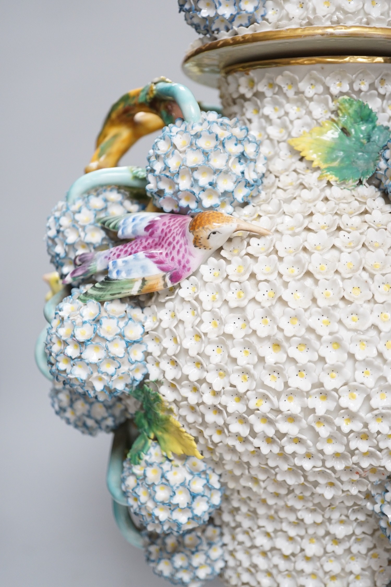 A large 19th century Jacob Petit floral encrusted two handled vase and cover, decorated with birds and flowers, 64cms high